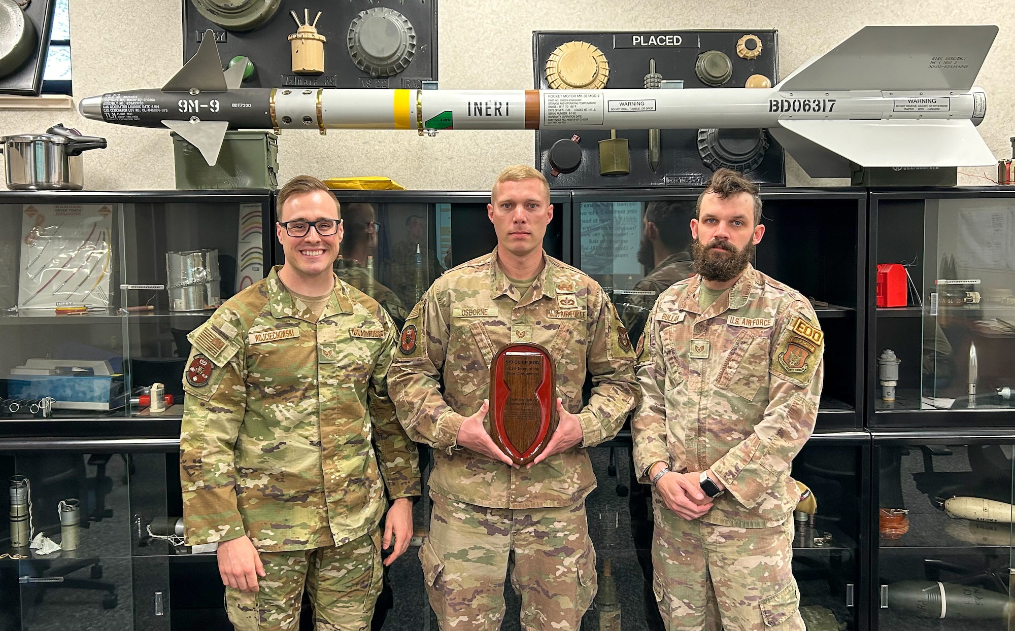 Staff Sgt. Stephan Wojciechowski, Tech. Sgt. David Osborne Jr. and Staff Sgt. Rockwood Bullard, all reservists assigned to the 434th Civil Engineer Squadron, Grissom Air Reserve Base, Ind., pose for a photo with their plaque, March 27, 2024. The trio received the plaque for placing third in the U.S. Army’s 52nd Ordnance Group Team of the Year competition held at Fort Campbell, Ky., March 11-15, 2024. (U.S. Air Force photo by Senior Airman Alexis Morris)