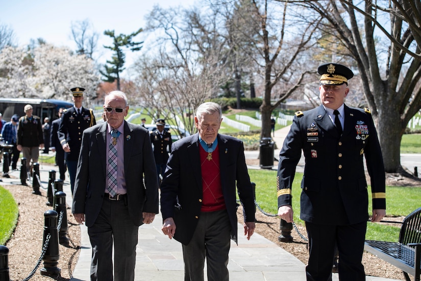 A group of people walk along a path.