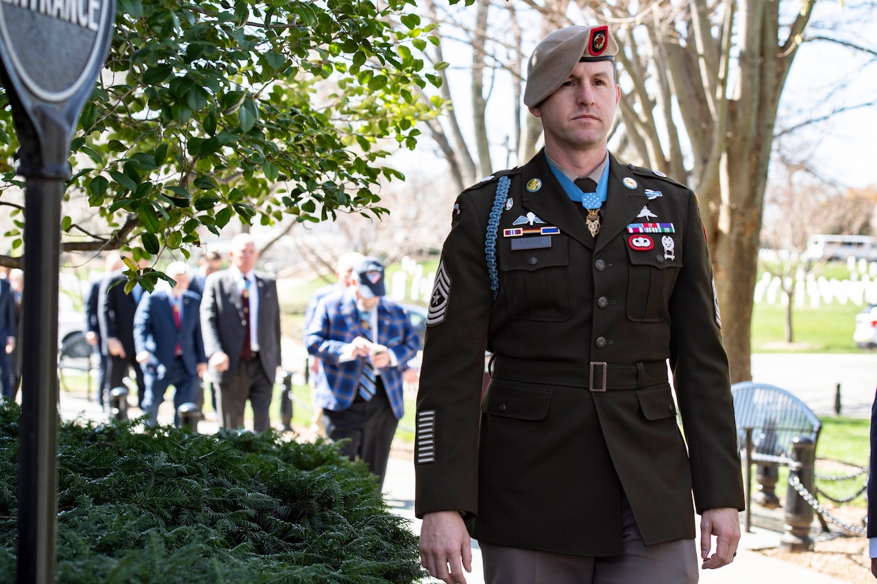 A military officer walks along a path.