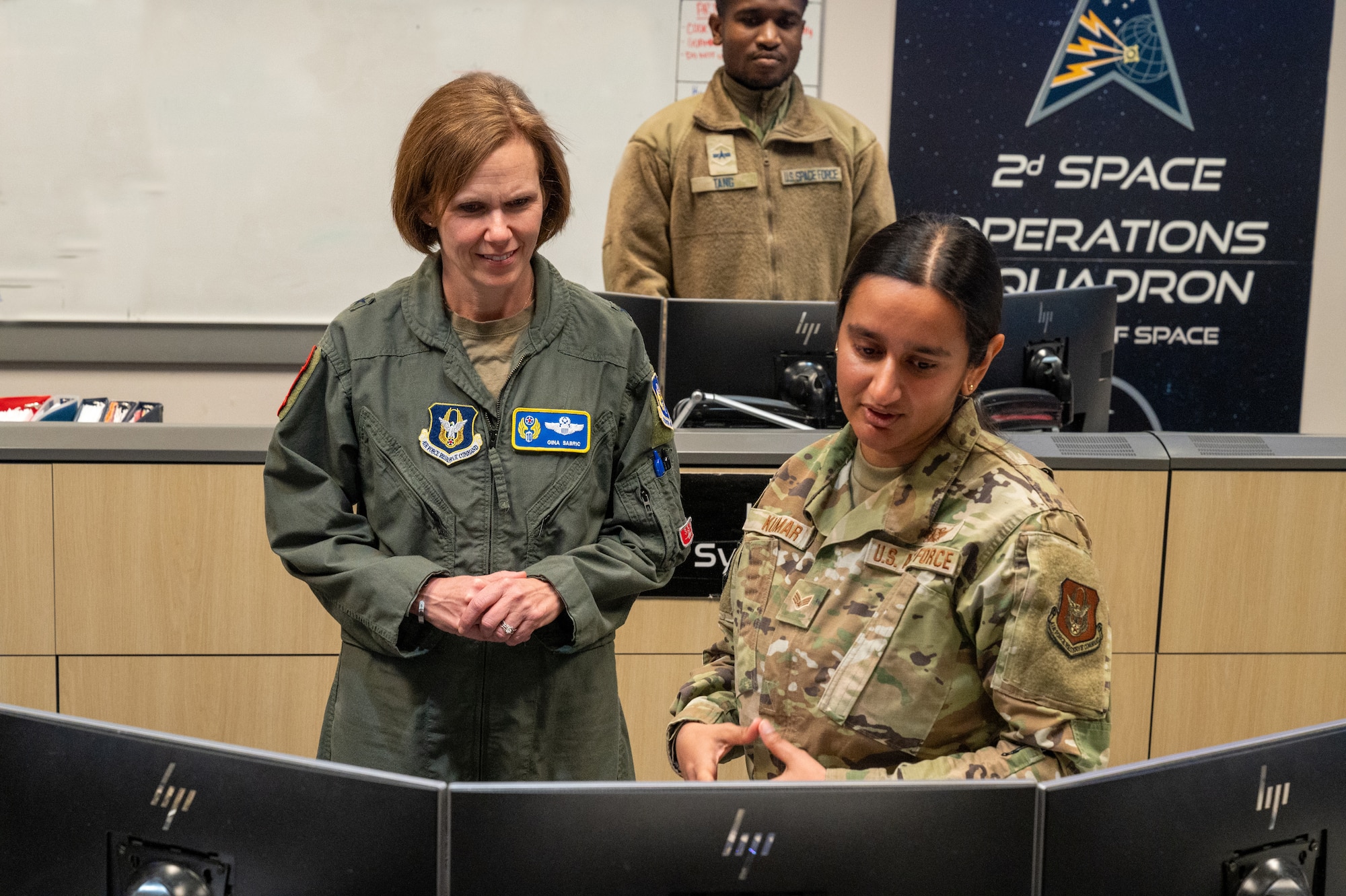 Two people in U.S. Air Force uniforms looking at computer screens.