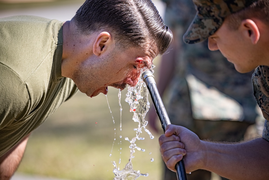 U.S. Marine Corps Warrant Officer Mason Shoemaker, left, a personnel officer with Headquarters and Support Battalion, Marine Corps Installations East-Marine Corps Base (MCB) Camp Lejeune, has his face rinsed off after being sprayed with oleoresin capsicum (O.C.) spray during the React Force Training course, on MCB Camp Lejeune, North Carolina, March 29, 2024. The O.C. spray training strengthened the Marines’ ability to suppress a threat in the event of being exposed to the substance. (U.S. Marine Corps photo by Lance Cpl. Loriann Dauscher)