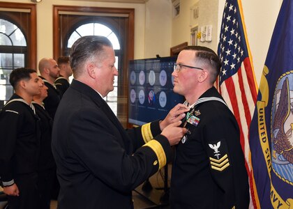 JOINT BASE SAN ANTONIO-FORT SAM HOUSTON – (March 29, 2024) – Hospital Corpsman 1st Class Brian Stemple, of Akron, Ohio, assigned to Naval Medical Leader and Professional Development Command (NMLPDC), was awarded the Navy and Marine Corps Commendation Medal by Rear. Adm. Walter Brafford, commander, Naval Medical Forces Support Command (NMFSC), at NMFSC headquarters.  Stemple, of Akron, Ohio, was recognized as NMLFDC’s Fiscal Year 2023 Sailor of the Year. NMFSC develops and delivers integrated education and training that produces operational medical experts to project Medical Power in support of Naval Superiority. (U.S. Navy photo by Burrell Parmer, Naval Medical Research Unit San Antonio Public Affairs/Released)