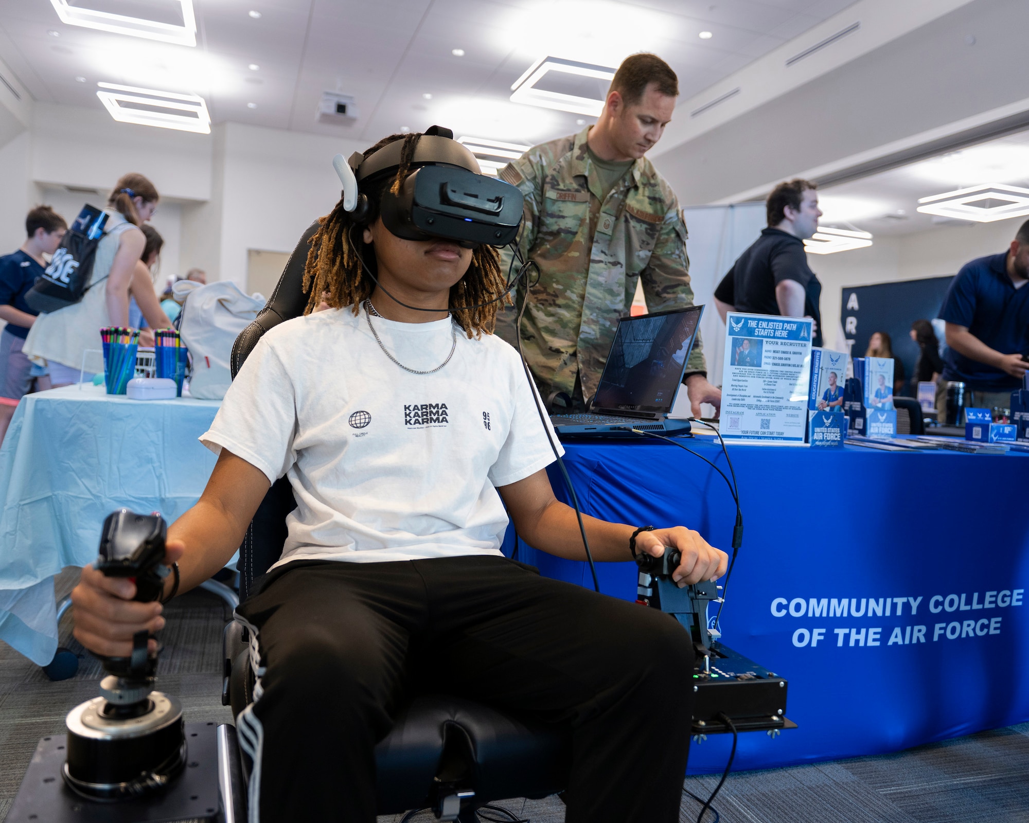 Jevin Allen, a 10th grader at Rockledge High School, checked out the virtual reality simulator as U.S. Air Force recruiter Master Sgt. Chase B. Griffin operates the simulator’s software.  With goggles firmly in place, the 16-year-old tested his ability to fly an F-35 and operate the refueling boom on a KC-135 at the 2024 Women in Science and Engineering Symposium hosted by the Air Force Technical Applications Center March 13, 2024.  (U.S. Air Force photo by Matthew S. Jurgens)