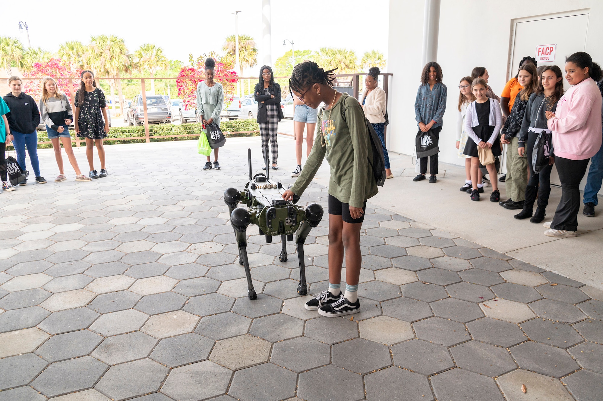 Na’Resse Butts, a 5th grader from Holland Elementary School in Brevard County, Fla., gets up-close-and-personal with Robo-Dog at the 2024 Women in Science and Engineering Symposium March 13, 2024.  The robotic dog, operated by the 45th Security Forces Squadron at Patrick Space Force Base, Fla., was one of nearly three dozen exhibits students from across Central Florida had the chance to see and interact with.  (U.S. Air Force photo by Susan A. Romano)