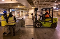 A photo of several people preparing a ship for cargo.