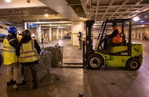 A photo of several people preparing a ship for cargo.
