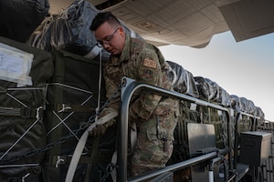 An Airman inspects humanitarian aid destined for Gaza loaded aboard a C-130.