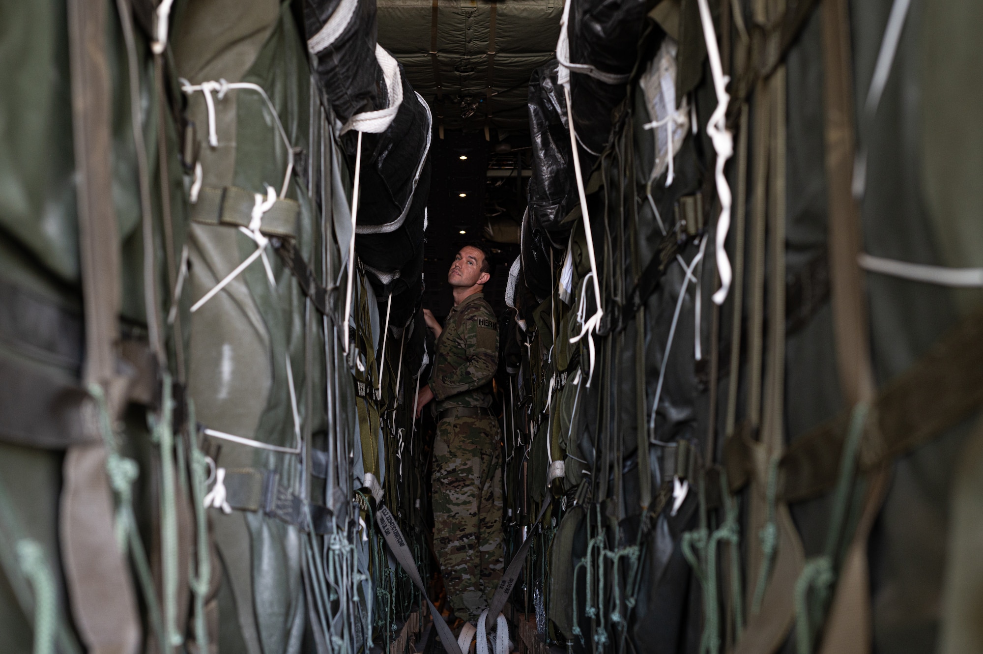 An Airman inspects pallets of humanitarian aid destined for Gaza aboard a C-130.