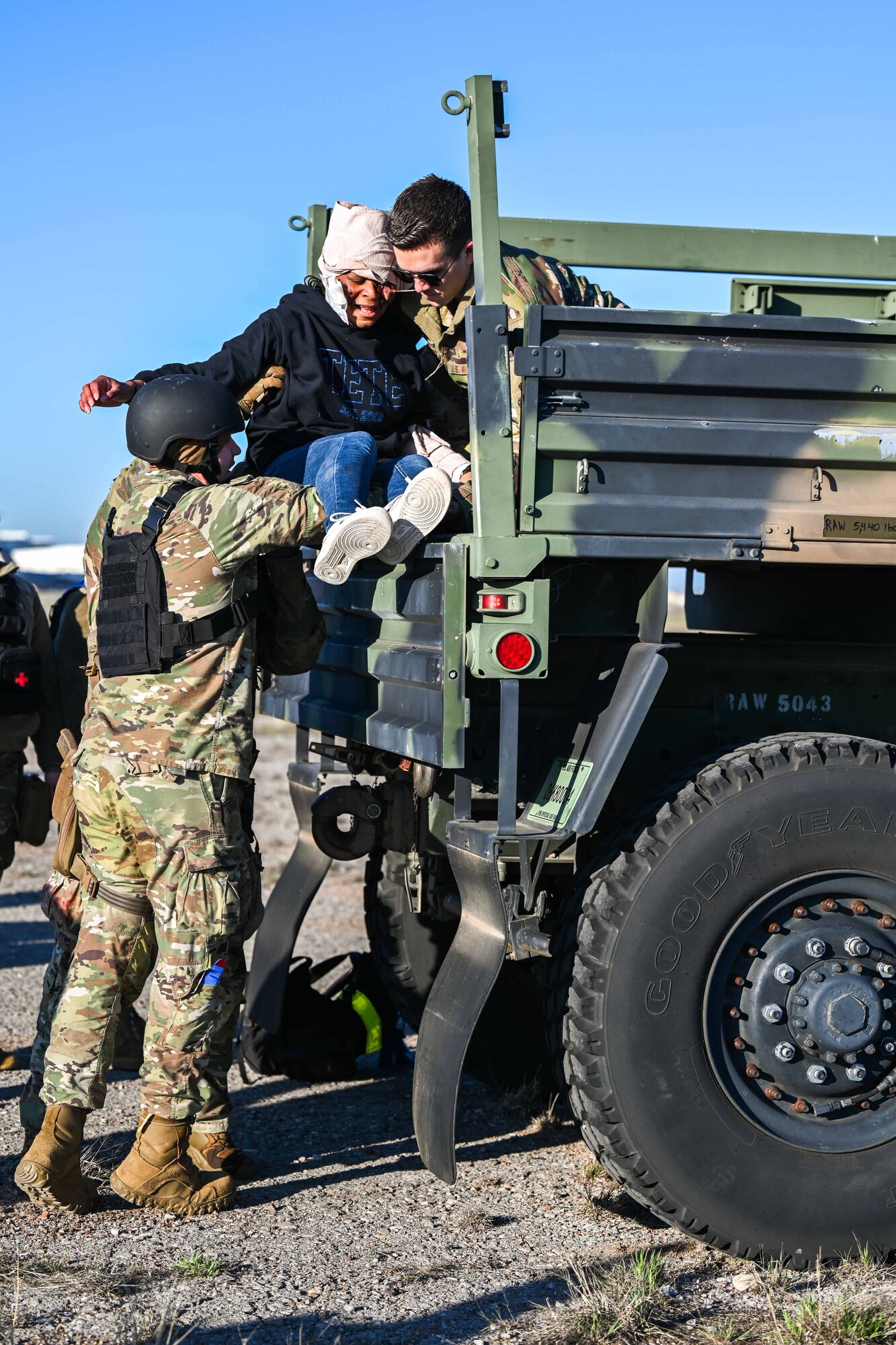 U.S. Air Force Senior Airman Alexander Fickas, 97th Logistics Readiness Squadron aerial operations apprentice, left, hands a patient to Staff Sgt. Andrew Chatfield, 58th Airlift Squadron instructor loadmaster, during Caduceus Spear at Altus Air Force Base, Oklahoma, March 28, 2024. The exercise sought to expose Airmen to challenging environments, in order to prepare them for the future fight. (U.S. Air Force photo by Airman 1st Class Jonah G. Bliss)