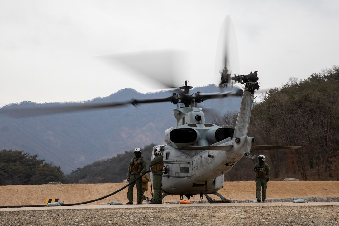 U.S. Marines with Marine Wing Support Squadron 172, Marine Aircraft Group 36, 1st Marine Aircraft Wing and Marine Light Attack Helicopter Squadron 369, Marine Aircraft Group 39, 3rd MAW, refuel a UH-1Y Venom helicopter at a forward arming and refueling point at Rodriguez Live Fire Range Complex, Pocheon, South Korea, March 11, 2024. Marines with Marine Air Control Squadron 4, MWSS-172, and 3rd Low Altitude Air Defense Battalion came together to execute a fortified FARP during Warrior Shield 24. Warrior Shield 24 is an annual joint, combined exercise held on the Korean Peninsula that seeks to strengthen the combined defensive capabilities of Republic of Korea and U.S. forces. This routine, regularly scheduled, field training exercise provides the ROK and U.S. Marines the opportunity to rehearse combined operations, exchange knowledge, and demonstrate the strength and capabilities of the ROK-US Alliance. (U.S. Marine Corps photo by Cpl. Tyler Harmon)