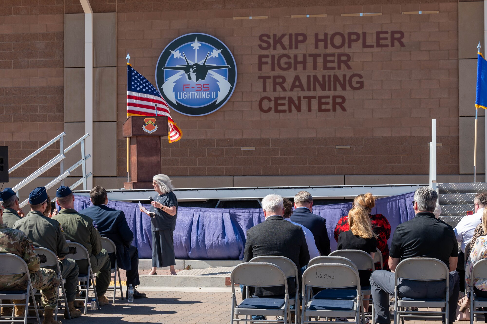 Heather Hopler, widow of U.S. Air Force retired Lt. Col. Edwin “Skip” Hopler, gives remarks during a renaming ceremony for the newly deemed Skip Hopler Fighter Training Center, March 29, 2024, at Luke Air Force Base, Arizona.