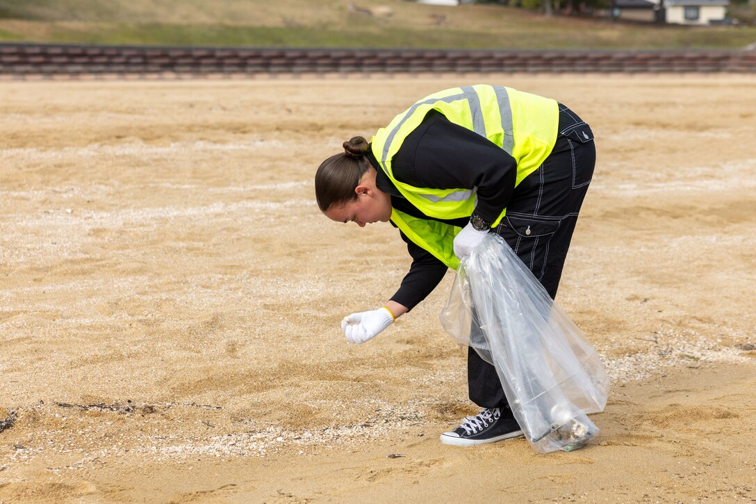 U.S. Marine Corps Lance Cpl. Evalyn Hoppe, a mobile facility technician with Marine Aviation Logistics Squadron 12, Marine Aircraft Group 12, and a native of Wisconsin, picks up trash during a beach cleanup at Yuu Beach, Iwakuni, Japan, March 19, 2024. Service members participated in a beach cleanup coordinated by the MCAS Iwakuni Single Marine Program and Marine Corps Community Services Iwakuni as a way to give back and build stronger relationships with the community. (U.S. Marine Corps Photo by Cpl. Calah Thompson)