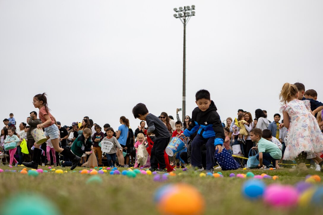 Children run to collect Easter eggs during an Easter egg hunt at Marine Corps Air Station Iwakuni, Japan, March 31, 2024. The MCAS Iwakuni Chapel and Marine Corps Community Services Iwakuni hosted an Easter egg hunt for the community to enjoy and share together while celebrating the holiday. (U.S. Marine Corps photo by Cpl. Peter Rawlins)