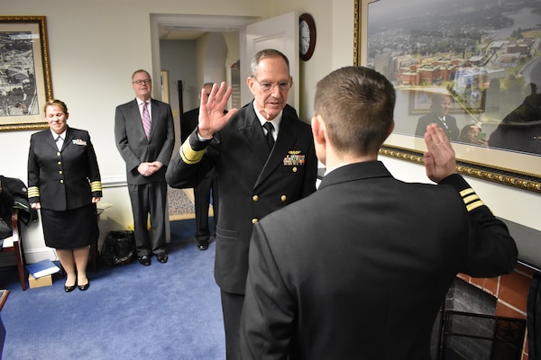 Rear Adm. Mittelman recites the officer oath of office to Capt. Christopher Barnes as he is frocked to his present rank.