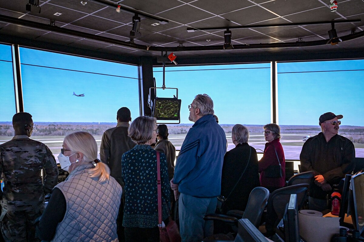 Nine people standing inside an air traffic control tower