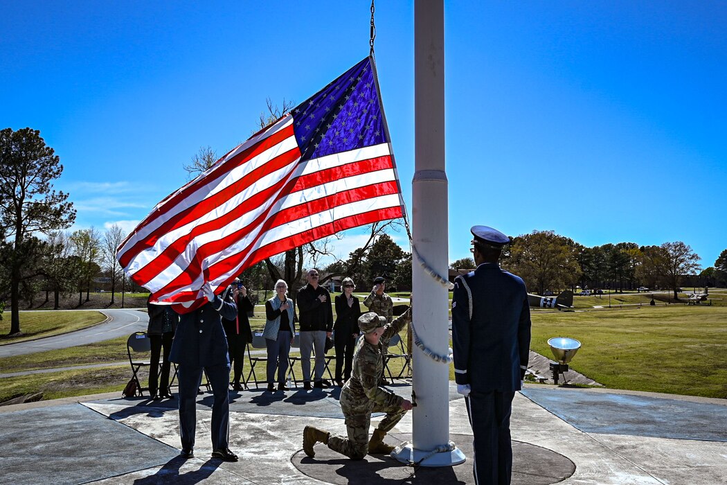 Airman lowers the flag during a ceremony