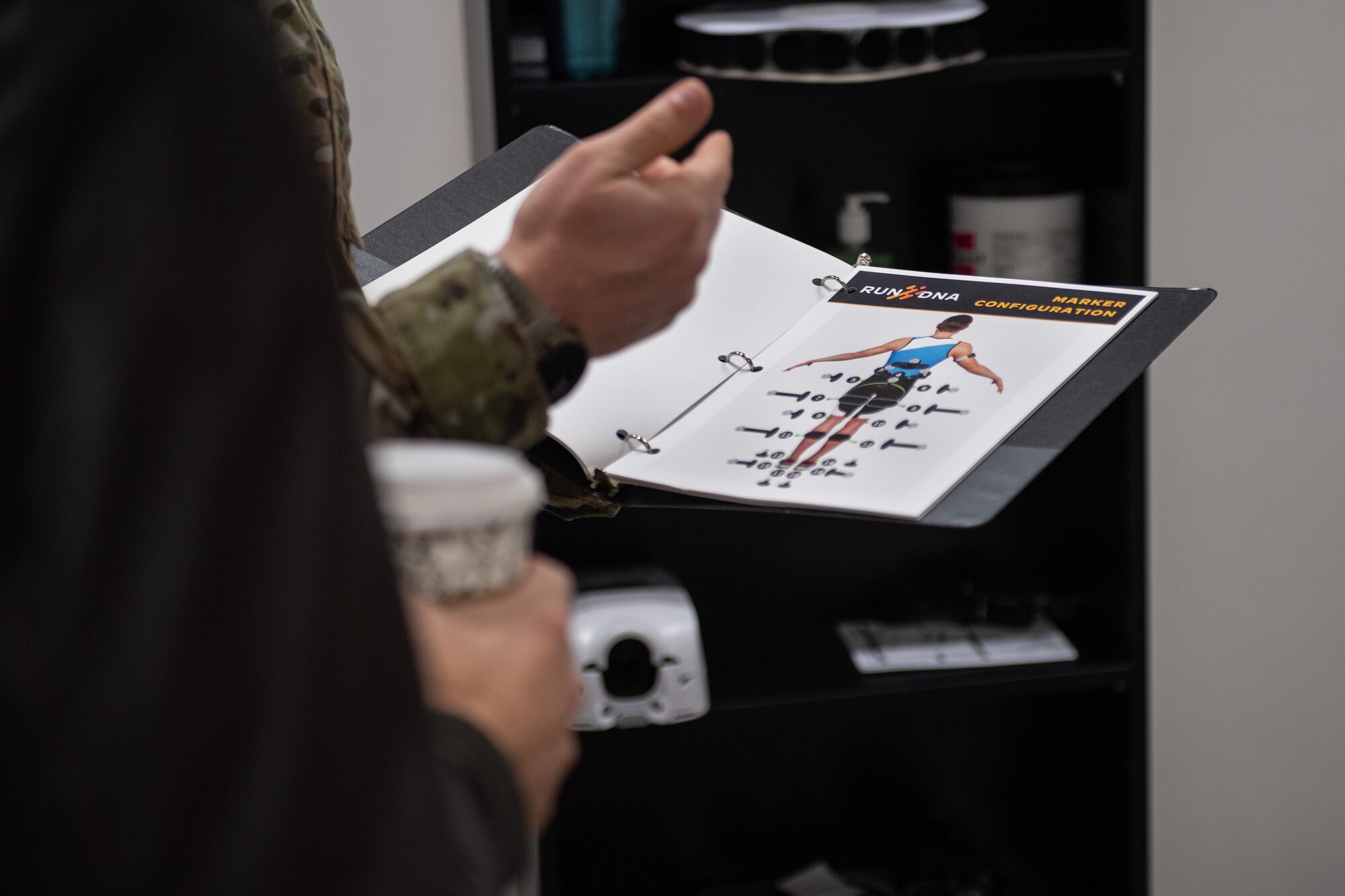 U.S. Air Force Capt. Jacob Kriegbaum, 39th Medical Group Operational Support Team element chief, briefs Col. Robert Schoeneberg, 39th Air Base Wing deputy commander, on the RunDNA system inside the new OST building at Incirlik Air Base, Türkiye, March 27, 2024. He is displaying a binder that shows the system's capabilities.