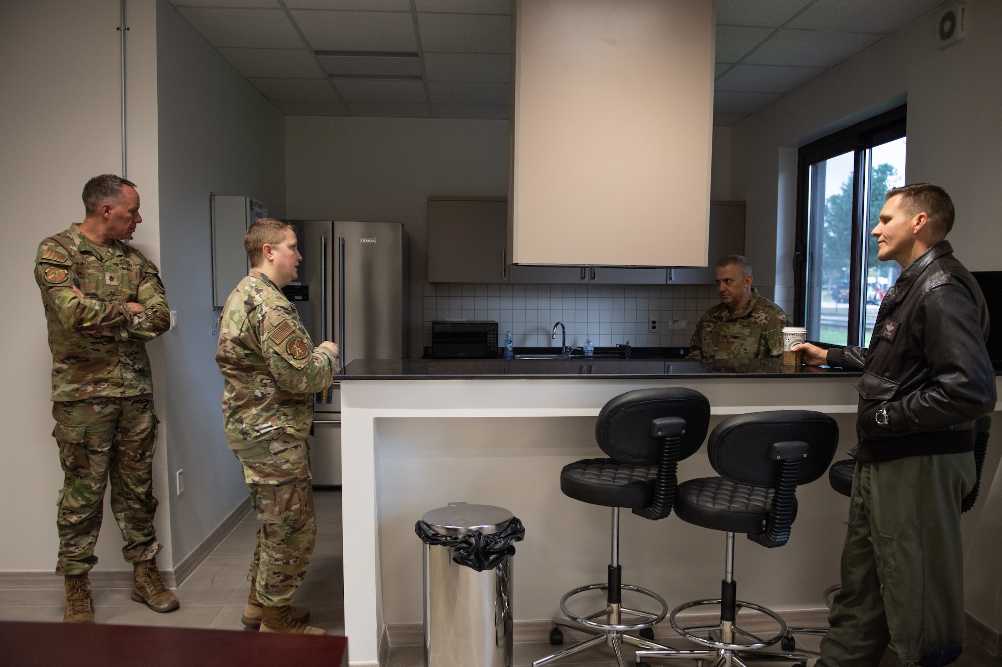 U.S. Air Force Capt. Cheven Bonnell, 39th Medical Group Operational Support Team element lead, briefs two Airmen inside the kitchen area about the new OST building capabilities.
