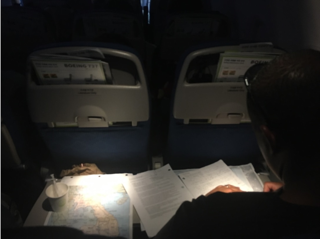 28 March 2024. School of Advanced Warfighting (SAW) student Major Tom Fiametta, USMC, on a flight from Guam to Incheon, prepares for the Vietnam battle stop that he will lead the following week as SAW conducts its annual Asia-Pacific Battle Staff Ride to the Philippines, Peleliu, Saipan, and Vietnam. (Photo by Colonel Greg Poland, USMC - SAW Director)