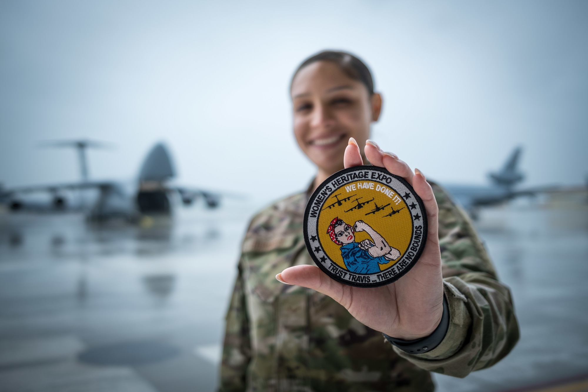 An airman holding a women's expo patch