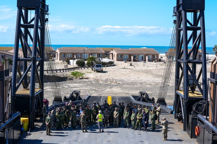 Members of the Demonstration & Assessment Team Battle Laboratory Division brief US Marines, civilian contractors, and foreign military leadership regarding the Stern Landing Vessel, a modified oil-rig industry off-shore support vessel, in order to inform them of potential safety hazards as part of Project Convergence Capstone 4, March 5, 2024 at the Del Mar Boat Basin, Camp Pendleton, CA. PC-C4 provided a unique opportunity for multiple Services and allies and partners to test the interoperability and integration of technologies and systems critical for responding to global contingencies and crises. PC-C4 is an Army-hosted, all-Service and multinational experiment. During PC-C4, the Marine Corps Warfighting Laboratory tested new technologies and capabilities and emerging concepts, including the multi-domain corridor. The Marine Corps’ participation in PC-C4 supported Force Design initiatives, integrated Joint force and Coalition capabilities into experimentation, and demonstrated the Marine Corps' commitment to the Joint Warfighting Concept.