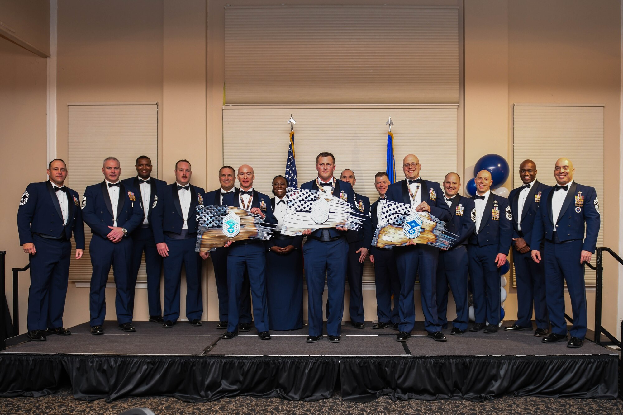 U.S. Air Force chief master sergeants pose for a group photo with recognition plaques during the chief master sergeant recognition ceremony at Seymour Johnson Air Force Base, North Carolina, March 2, 2024. These current and recently selected leaders were recognized as part of the one percent of service members who hold the rank of chief master sergeant. (U.S. Air Force photo by Senior Airman Taylor Hunter)