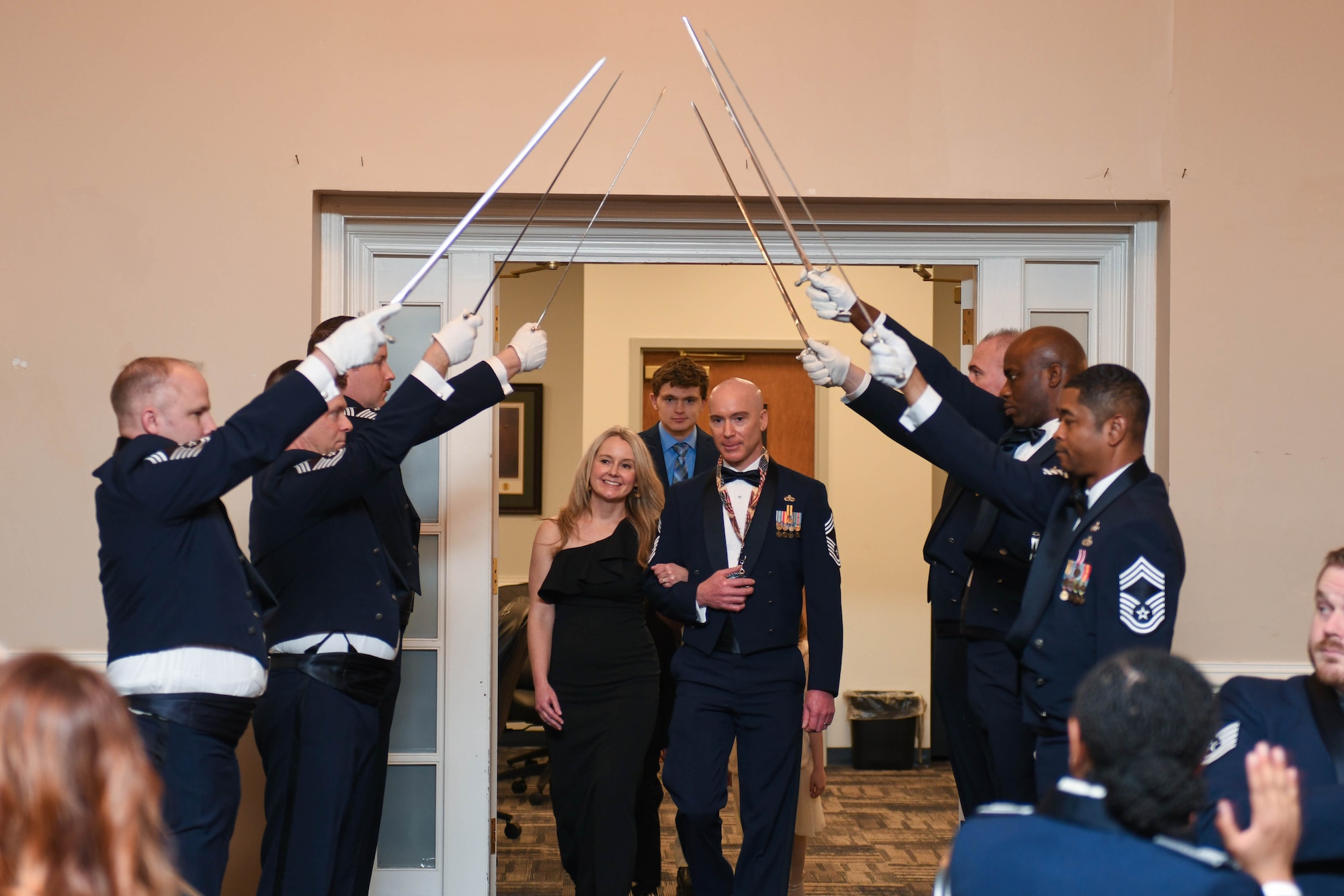 U.S. Air Force Chief Master Sgt. Karl Rehkamp, select, with the 916th Maintenance Group, walks with spouse, Chloe, through a saber cordon during the chief master sergeant recognition ceremony at Seymour Johnson Air Force Base, North Carolina, March 2, 2024. The rank of chief master sergeant was established by Congress in 1958. They are responsible for embodying the Air Force core values and possess attributes needed to serve at the highest enlisted grade. (U.S. Air Force photo by Senior Airman Taylor Hunter)