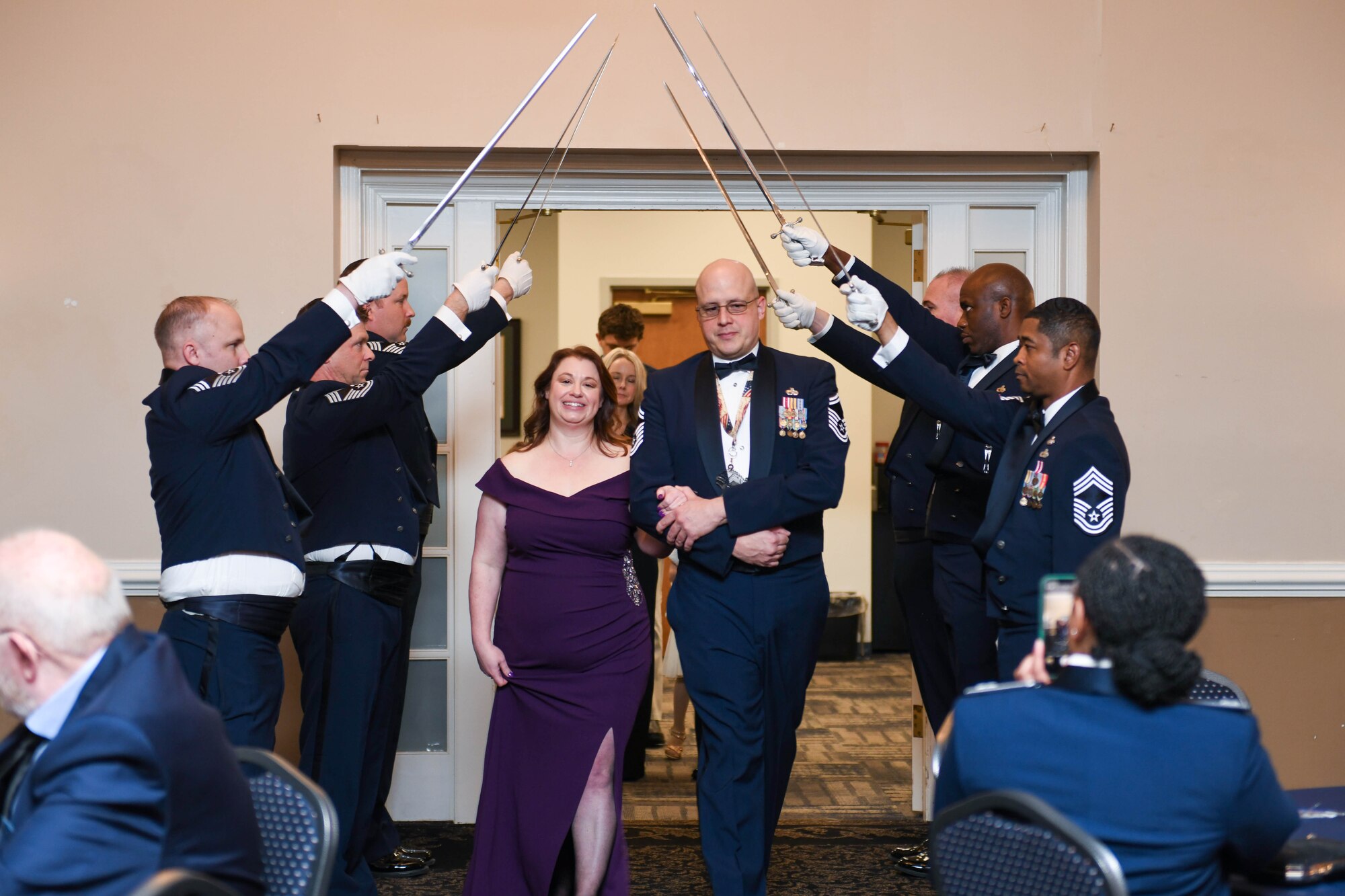 U.S. Air Force Chief Master Sgt. Benjamin Griffin, select, with the 916th Air Refueling Wing, walks with his spouse, Amanda, through a saber cordon during the chief master sergeant recognition ceremony at Seymour Johnson Air Force Base, North Carolina, March 2, 2024. The rank of chief master sergeant was established by Congress in 1958. They are responsible for embodying the Air Force core values and possess attributes needed to serve at the highest enlisted grade. (U.S. Air Force photo by Senior Airman Taylor Hunter)