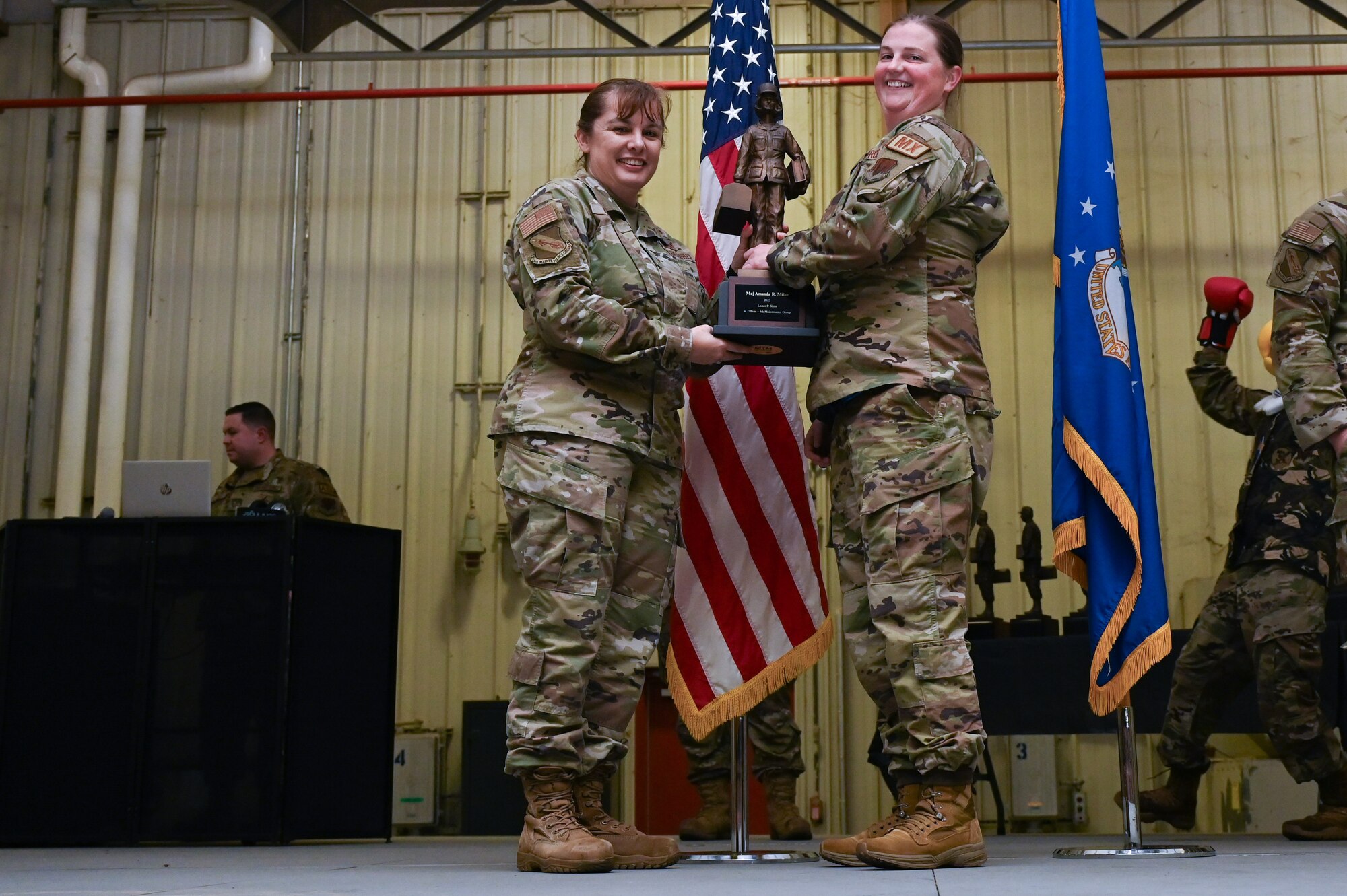 Maj. Amanda Miller, center, assigned to the 334th Fighter Generation Squadron, receives the Lance P. Sijan Award from Col. Kathryn Roman, 4th Maintenance Group commander and Chief Master Sgt. Michael Bylica, 4 MXG senior enlisted leader, during the 4 MXG Maintenance Person of the Year ceremony at Seymour Johnson Air Force Base, North Carolina, Mar. 08, 2024. The 4th Maintenance Group hosts the event annually for MXG Airmen to celebrate their achievements and hard work. (U.S. Air Force photo by Airman Rebecca Tierney)