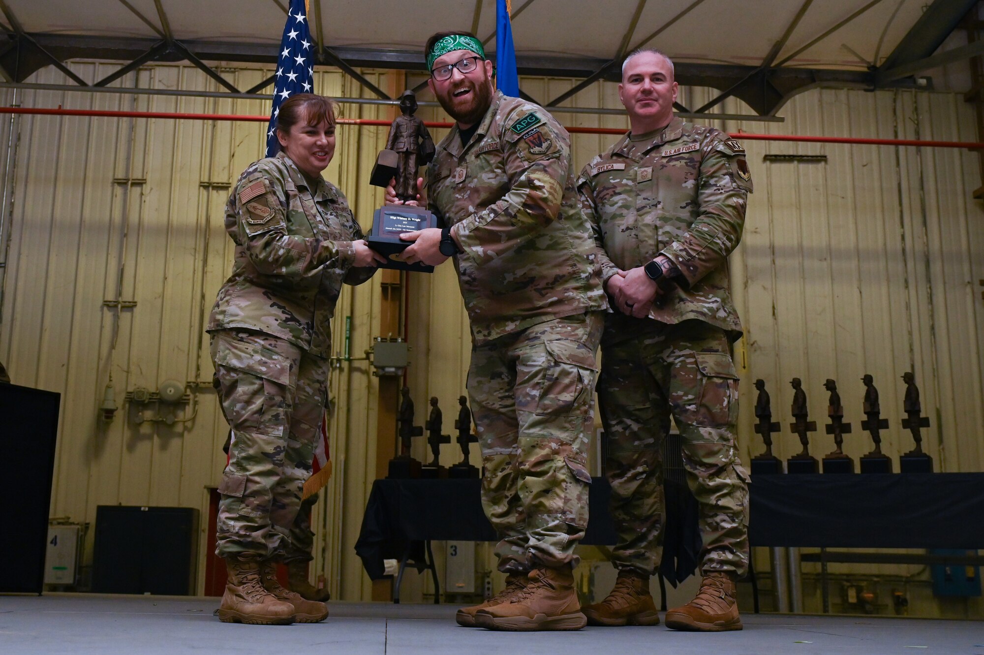 Staff Sgt. Whitney Wright, center, assigned to the 335th Fighter Generation Squadron, receives the Lt. General Leo Marquez award from Col. Kathryn Roman, 4th Maintenance Group commander and Chief Master Sgt. Michael Bylica, 4 MXG senior enlisted leader, during the 4 MXG Maintenance Person of the Year ceremony at Seymour Johnson Air Force Base, North Carolina, Mar. 08, 2024. The 4th Maintenance Group hosts the event annually for MXG Airmen to celebrate their achievements and hard work. (U.S. Air Force photo by Airman Rebecca Tierney)