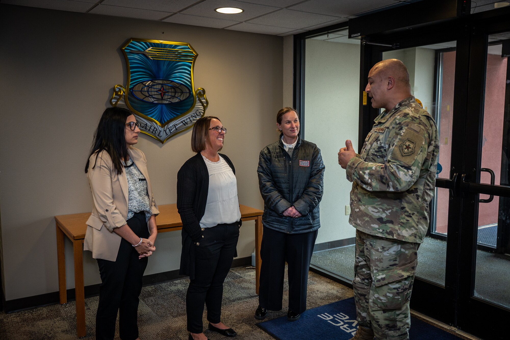 Megan Kidd, USO Missouri Field Program Specialist, Rebecca Parkes, USO Regional President, and Amanda Schmidt, USO Missouri Executive Director chat with Col. Jeffrey Smith, 932nd Airlift Wing commander, during an initial visit to the 932nd AW, March 26, 2024, Scott Air Force  (U.S. Air Force photo by Christopher Parr)