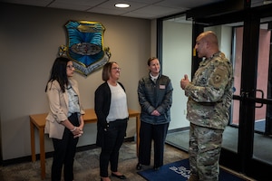 Megan Kidd, USO Missouri Field Program Specialist, Rebecca Parkes, USO Regional President, and Amanda Schmidt, USO Missouri Executive Director chat with Col. Jeffrey Smith, 932nd Airlift Wing commander, during an initial visit to the 932nd AW, March 26, 2024, Scott Air Force  (U.S. Air Force photo by Christopher Parr)