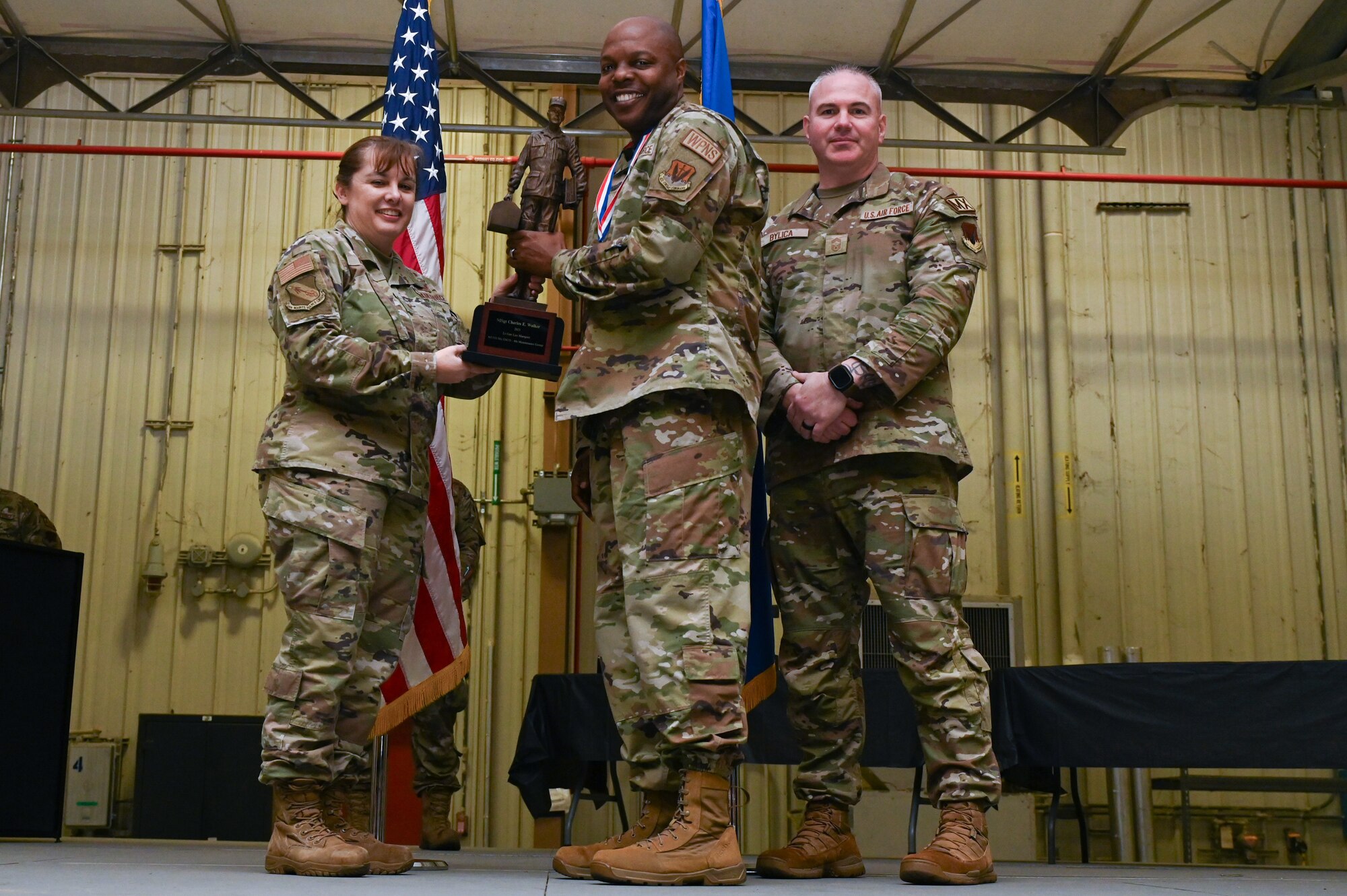 Master Sgt. Charles Walker, assigned to the 335th Fighter Generation Squadron, receives the Lt. General Leo Marquez award from Col. Kathryn Roman, 4th Maintenance Group commander and Chief Master Sgt. Michael Bylica, 4 MXG senior enlisted leader, during the 4 MXG Maintenance Person of the Year ceremony at Seymour Johnson Air Force Base, North Carolina, Mar. 08, 2024. The 4th Maintenance Group hosts the event annually for MXG Airmen to celebrate their achievements and hard work. (U.S. Air Force photo by Airman Rebecca Tierney)
