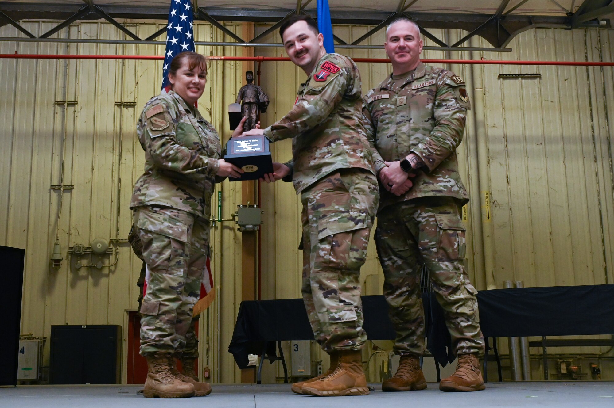 Staff Sgt. Jeffery Motley, assigned to the 4th Equipment Maintenance Squadron, receives the Maintenance Professional of the Year award from Col. Kathryn Roman, 4th Maintenance Group commander and Chief Master Sgt. Michael Bylica, 4 MXG senior enlisted leader, during the 4 MXG Maintenance Person of the Year ceremony at Seymour Johnson Air Force Base, North Carolina, Mar. 08, 2024. The 4th Maintenance Group hosts the event annually for MXG Airmen to celebrate their achievements and hard work. (U.S. Air Force photo by Airman Rebecca Tierney)
