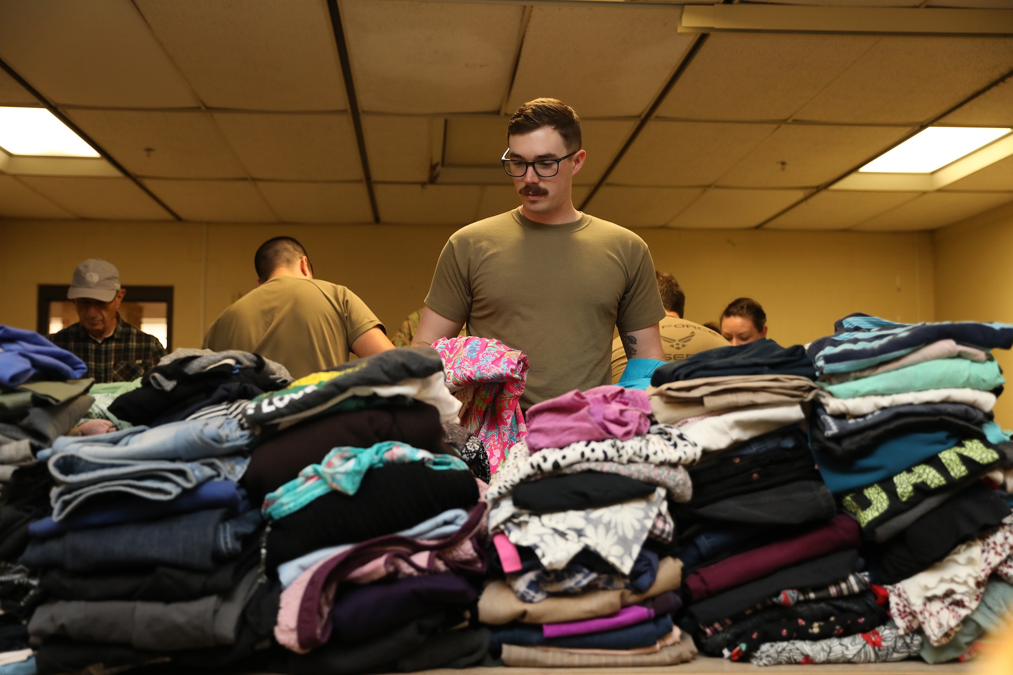 Staff Sgt. Carter Lee, 87th Aerial Port Squadron load planning craftsman, sorts and folds donated clothing items at the Bridges of Hope homeless shelter in Xenia, Ohio, March 10, 2024. (U.S. Air Force photo/Senior Airman Angela Jackson)