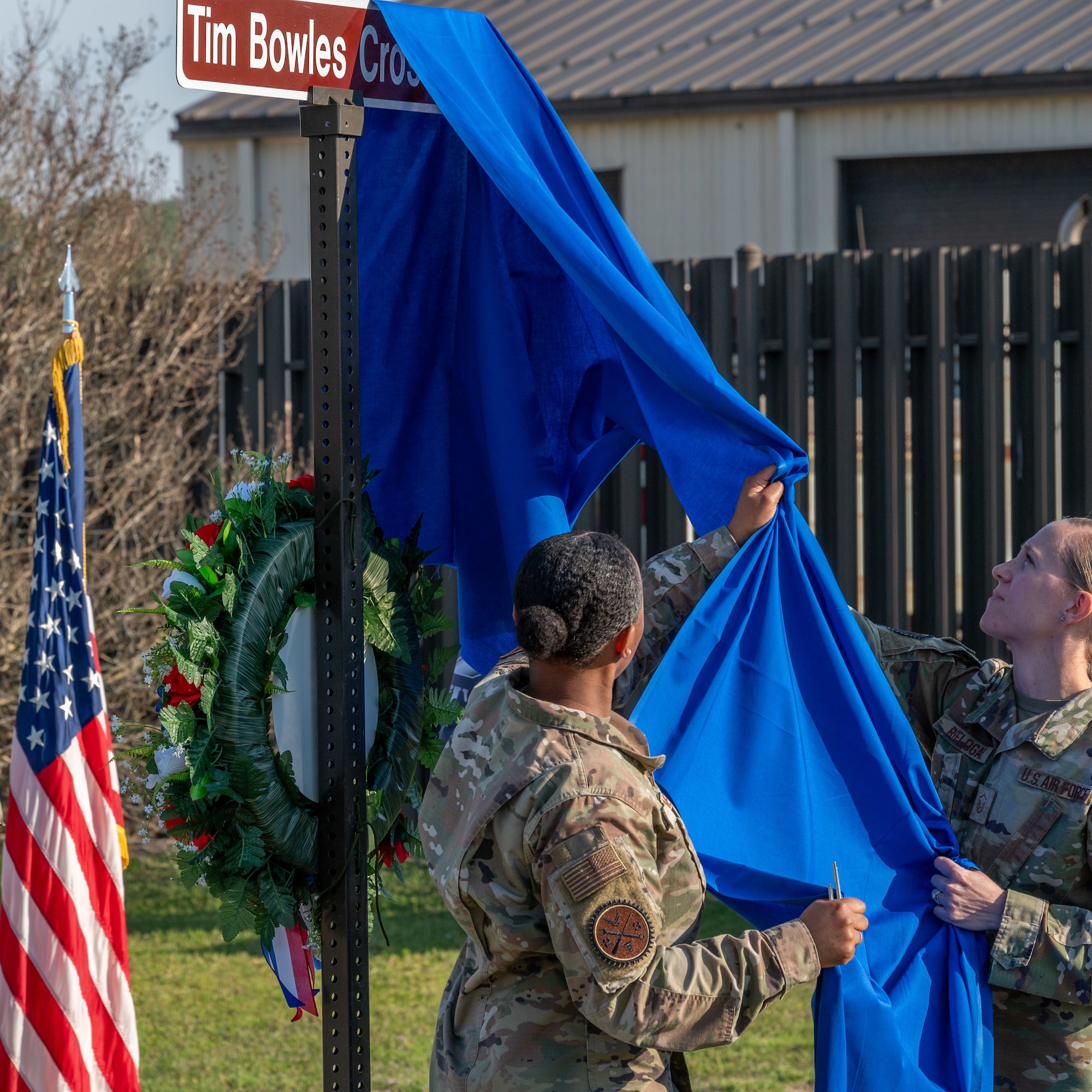 U.S. Air Force Master Sgt. Tammy Reflogal, right, Vehicle Management flight chief and 1st Lt. Jade Hiderjones, left, Vehicle Management flight commander, reveal a fallen airman memorial crosswalk at Seymour Johnson Air Force Base, North Carolina, March 15, 2024. For his sacrifice Staff Sgt. Timothy Bowles was posthumously awarded the Purple Heart and Bronze Star. (U.S. Air Force photo by Airman 1st Class Leighton Lucero)