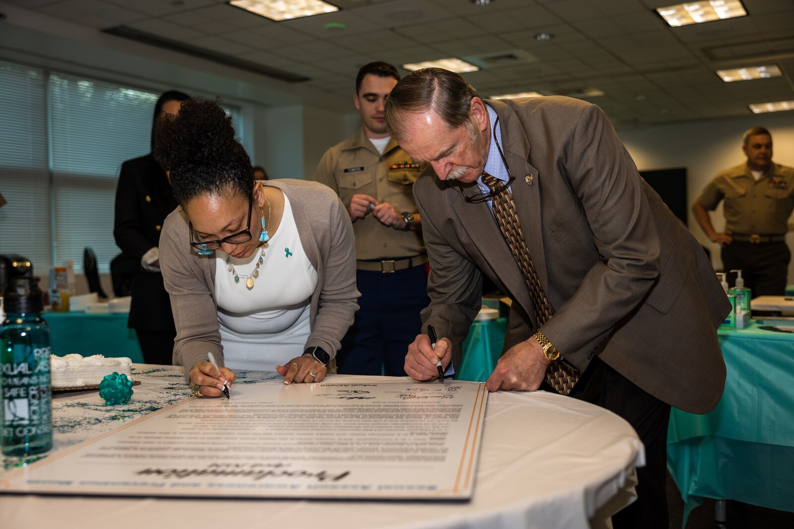 U.S. Marines and civilians with the Wounded Warrior Regiment, sign the proclamation during the Sexual Assault Awareness and Prevention Month proclamation signing and cake cutting ceremony on Marine Corps Base Quantico, Virginia, March 29, 2024. SAAPM aims to raise public awareness about sexual violence and educate communities about prevention. (U.S. Marine Corps photo by Lance Cpl. Joaquin Dela Torre)