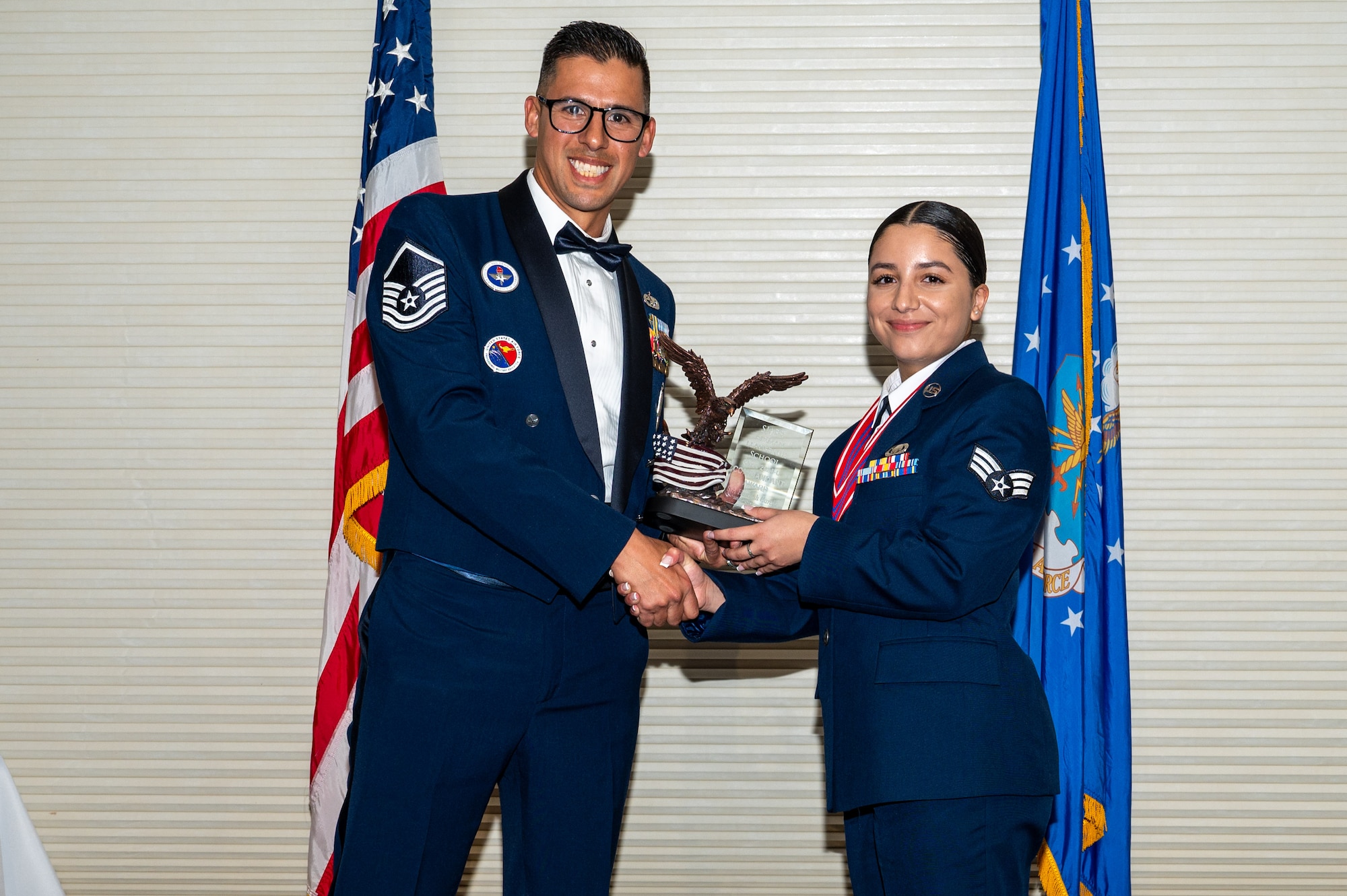 Senior Airman Hannah Garcia, assigned to the 335th Fighter Squadron, right, receives the Commandant’s Award from Master Sgt. Mark Benevides, Airman Leadership School instructor, during the ALS class 24-C graduation ceremony at Seymour Johnson Air Force Base, North Carolina, Mar. 20, 2024. The Commandant’s Award is presented to an ALS graduate that possessed the highest degree of character, competence, and commitment during the ALS course. (U.S. Air Force photo by Airman Rebecca Tierney)