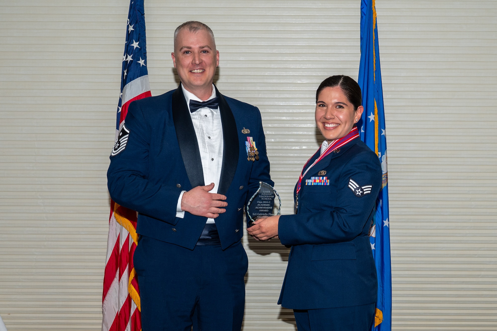 Senior Airman Gabriella Flores, assigned to the 336th Fighter Squadron, right, receives the Academic Achievement Award from Master Sgt. Peter Creighton, 333rd Fighter Generation Squadron first sergeant, during the Airman Leadership School class 24-C graduation ceremony at Seymour Johnson Air Force Base, North Carolina, Mar. 20, 2024. The students presented with the Academic Achievement Award maintained the highest grade point average throughout the ALS course. (U.S. Air Force photo by Airman Rebecca Tierney)