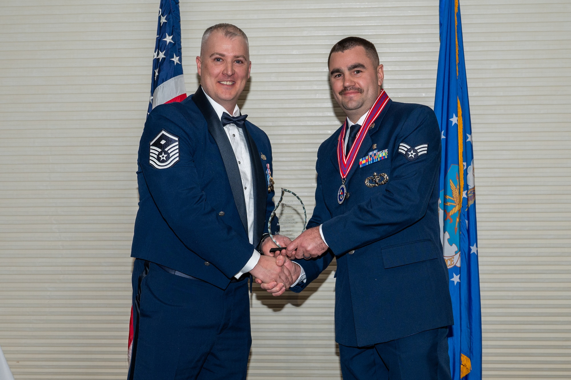 Senior Airman Derrick Shaw, assigned to the 335th Fighter Squadron, right, receives the Academic Achievement Award from Master Sgt. Peter Creighton, 333rd Fighter Generation Squadron first sergeant, during the Airman Leadership School class 24-C graduation ceremony at Seymour Johnson Air Force Base, North Carolina, Mar. 20, 2024. The students presented with the Academic Achievement Award maintained the highest grade point average throughout the ALS course. (U.S. Air Force photo by Airman Rebecca Tierney)
