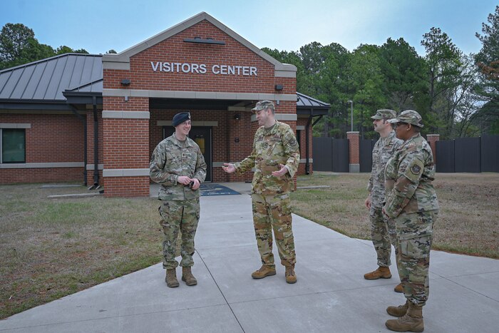 Four Airmen talking in a group outside.