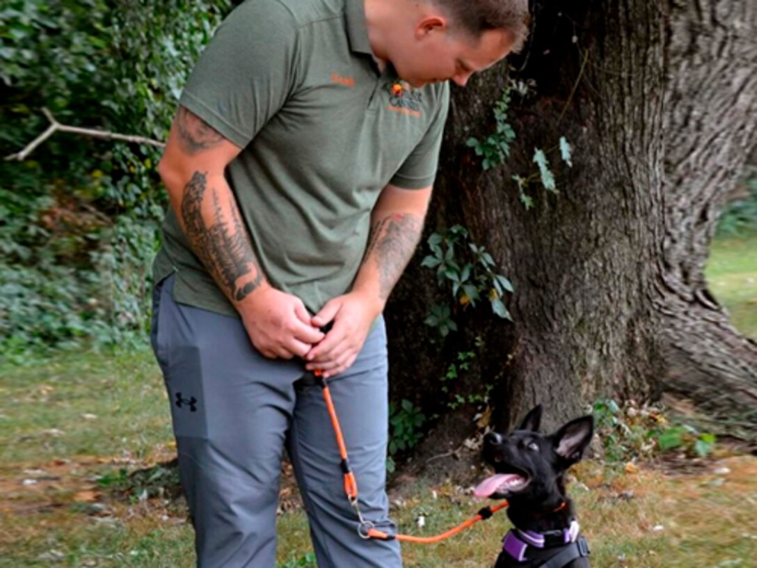 Staff Sgt. Devin Fink trains a dog at his volunteer job.
