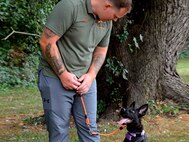 Staff Sgt. Devin Fink trains a dog at his volunteer job.