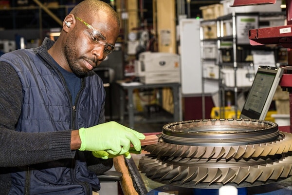 Turbine Power Plant Mechanic Linus Nyamoko blends the first and second stage brisk of an F414 High Pressure Compressor Stator (HPC) at Fleet Readiness Center Southeast. The F414 engine powers the Navy's F/A-18E/F Super Hornet and EA-18G Growler aircraft.