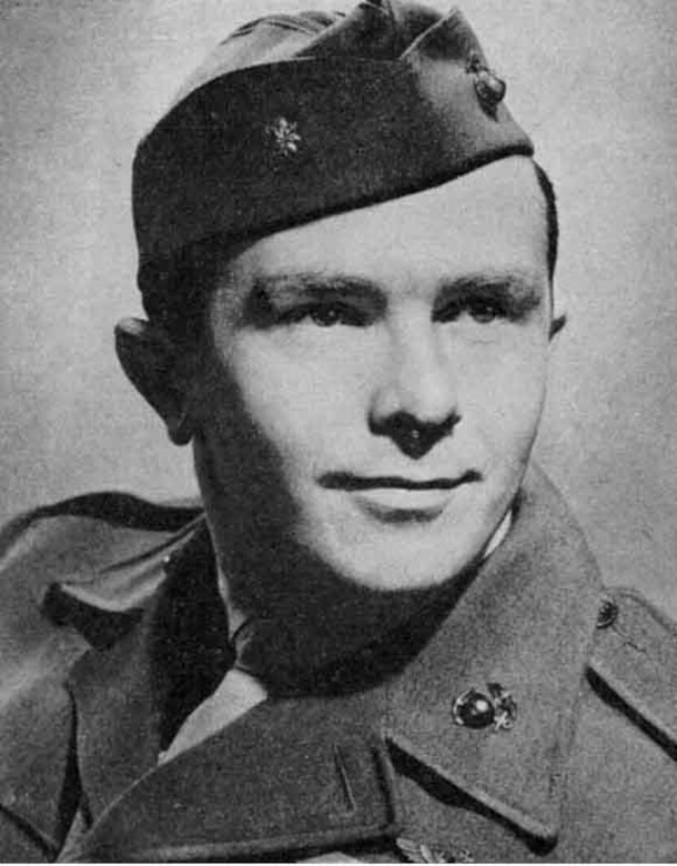 A man in a military cap poses for a photo.