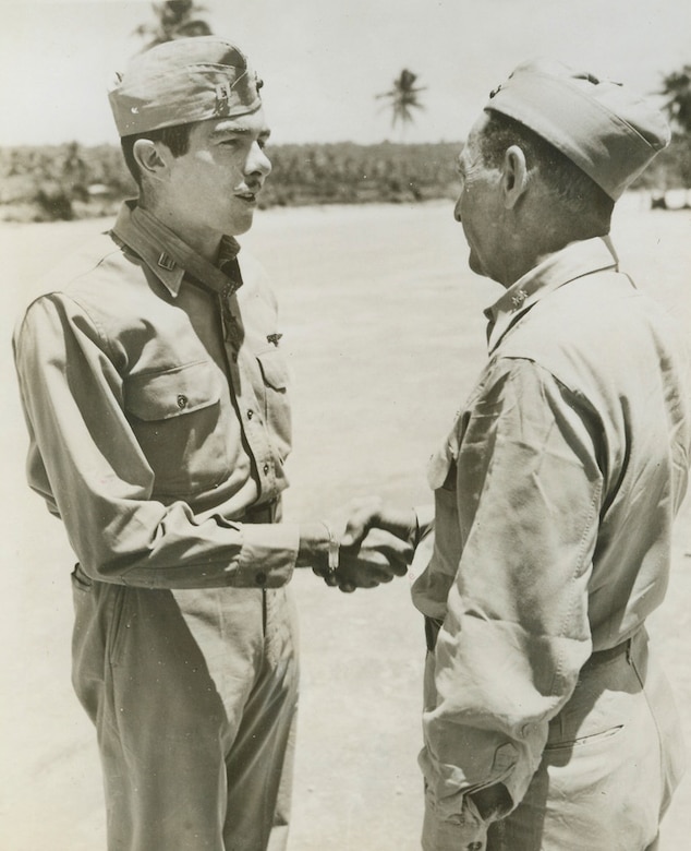 Two men in uniform shake hands.