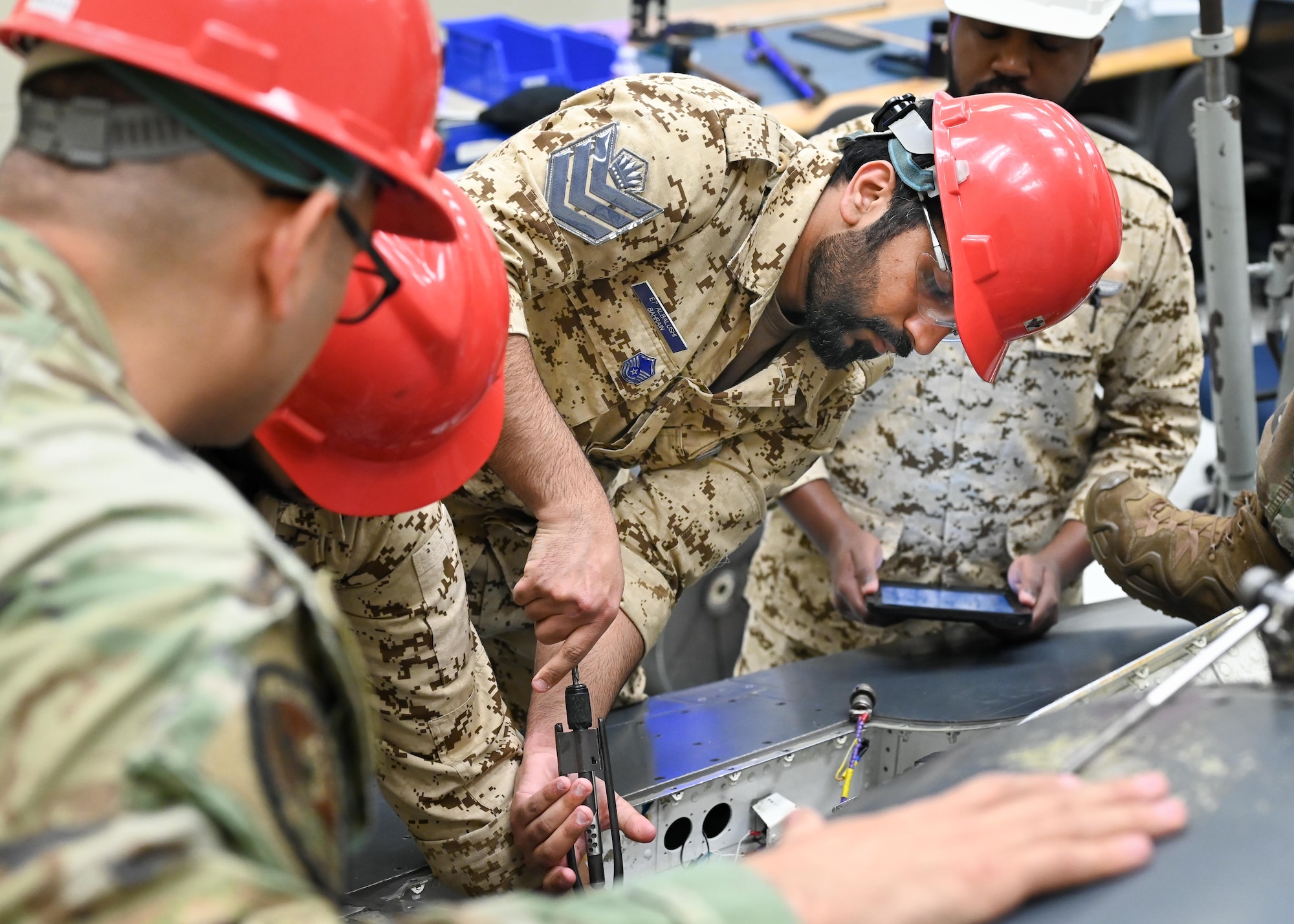 A group of men work on an aircraft part.