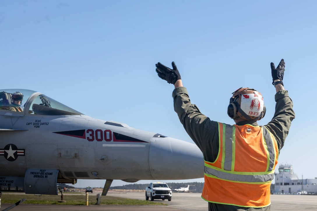 U.S. Marine Corps Cpl. Brandon Buck, a bulk fuel specialist assigned to Headquarters and Headquarters Squadron, Marine Corps Air Station Cherry Point, signals to the pilot of an F/A-18E Super Hornet, assigned to Strike Fighter Squadron 31, Naval Air Force Atlantic, on the flight line at MCAS Cherry Point, North Carolina, March 21, 2024. MCAS Cherry Point Station Fuels is responsible for receiving, testing, storing, and dispensing various petroleum products in support of ground and aviation operations on the installation. (U.S. Marine Corps photo by Lance Cpl. Lauralle Gavilanes)
