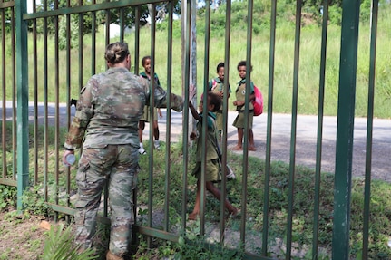 Staff Sgt. Victoria Wickersheim, of the Wisconsin National Guard’s 115th Security Forces Squadron, greets Papua New Guinea children during a break from security training March 18, 2024, as part of a visit by 40 Wisconsin National Guard members to Papua New Guinea in support of the State Partnership Program. The Wisconsin National Guard and Papua New Guinea began their partnership in 2020.