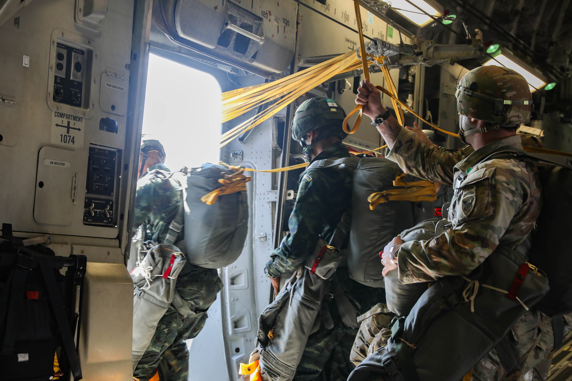 Soldiers getting ready to jump out of an aircraft.
